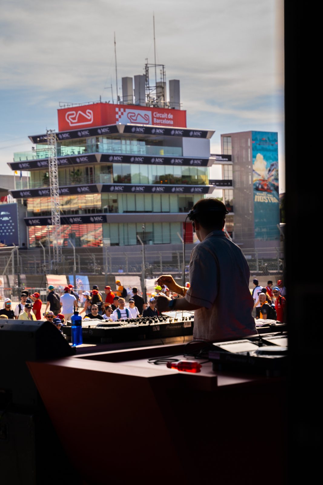 DJ silhouetted against the Circuit de Barcelona-Catalunya control tower at the Casa Très takeover.