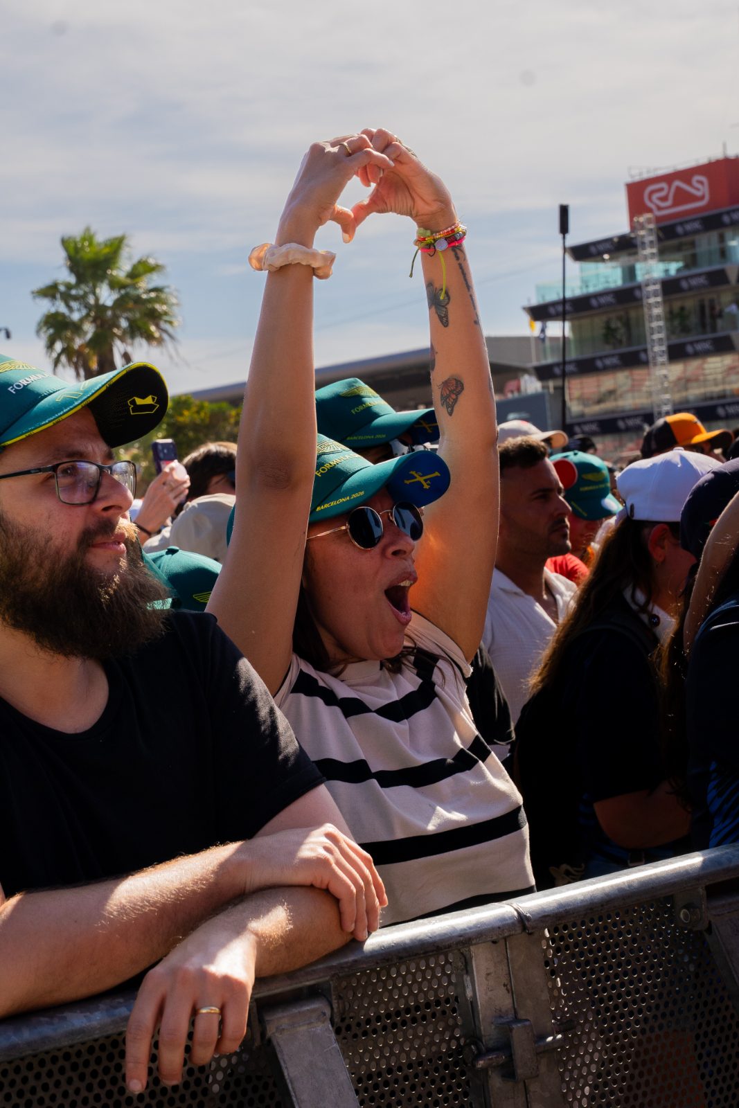 Fan in a Formula 1 Barcelona 2026 cap making a heart sign at a Casa Très set